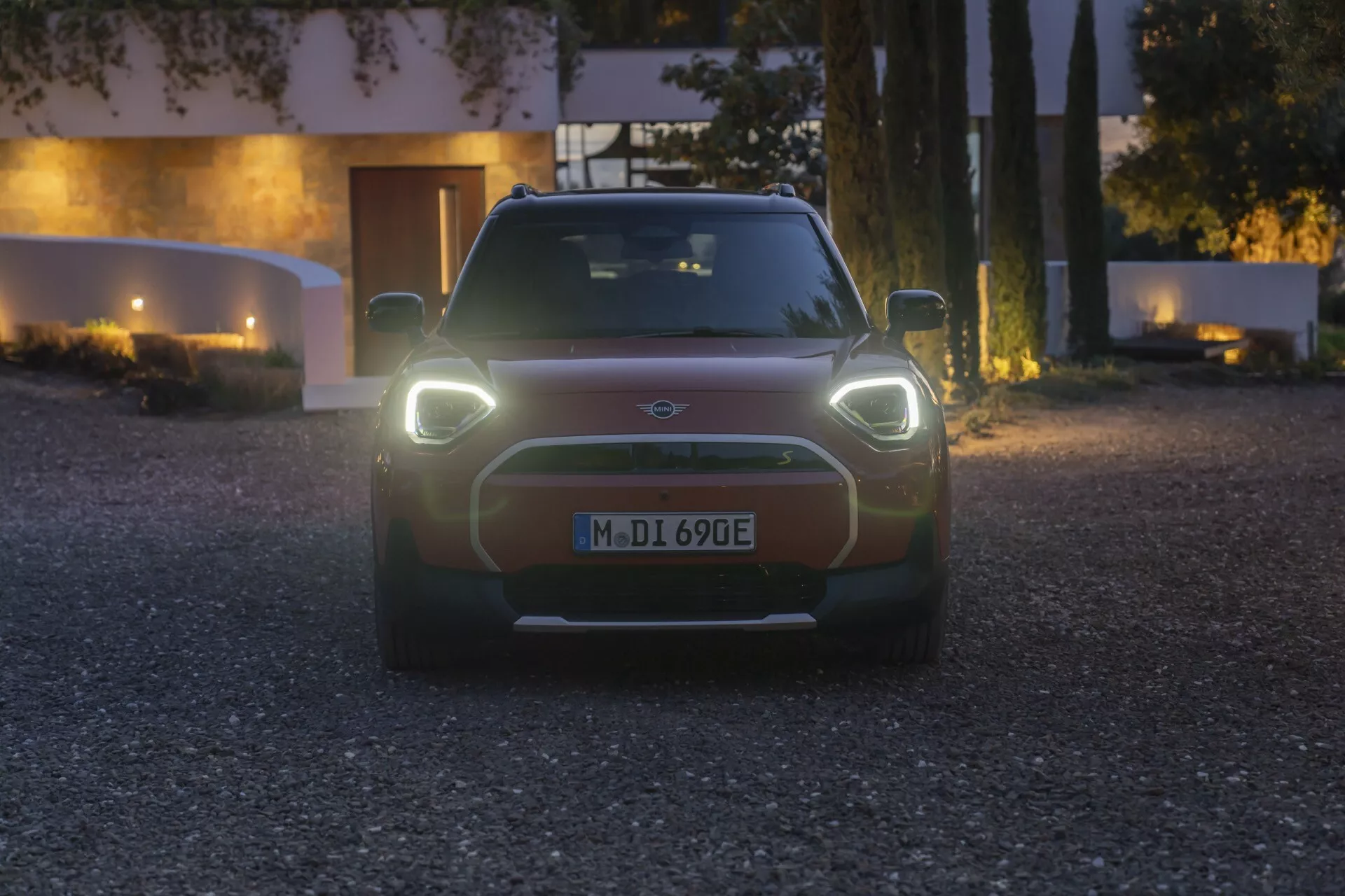 Front view of the 2024 Mini Aceman (J05) showcasing its dynamic design and LED headlights in twilight conditions, highlighting advanced automotive technology and sleek aerodynamics