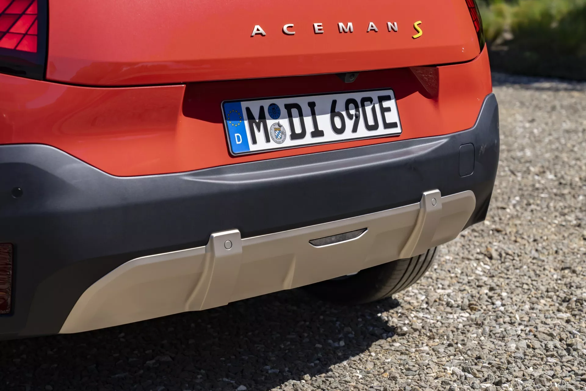 Close-up of Mini Aceman 2024's rear featuring ACEMANS lettering, modern LED tail light design, European license plate, and parking sensors on red bodywork, suggesting an electric or hybrid model.