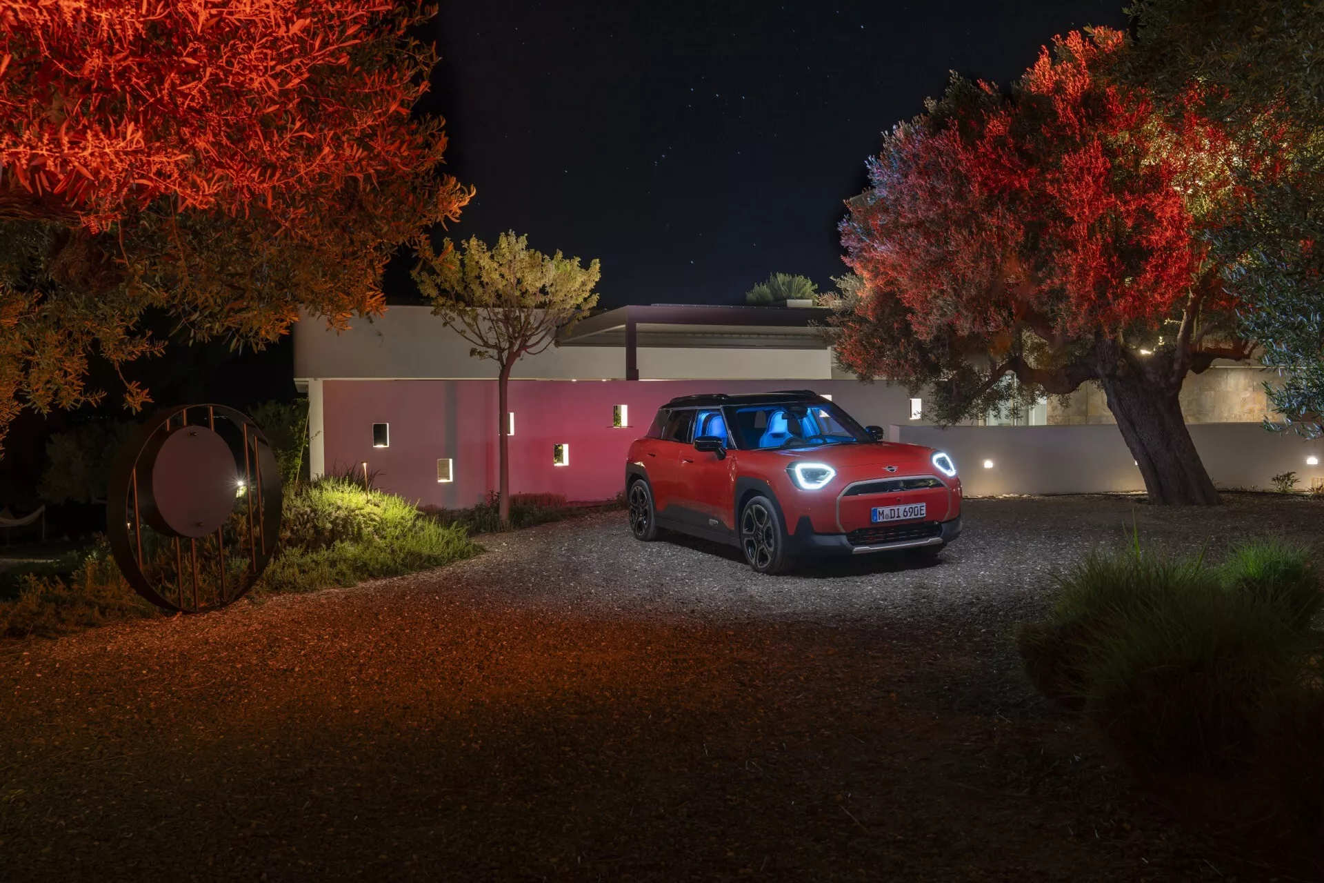 2024 Mini Aceman (J05) Compact SUV Frontal View at Night on a Rural Path with Illuminated Trees