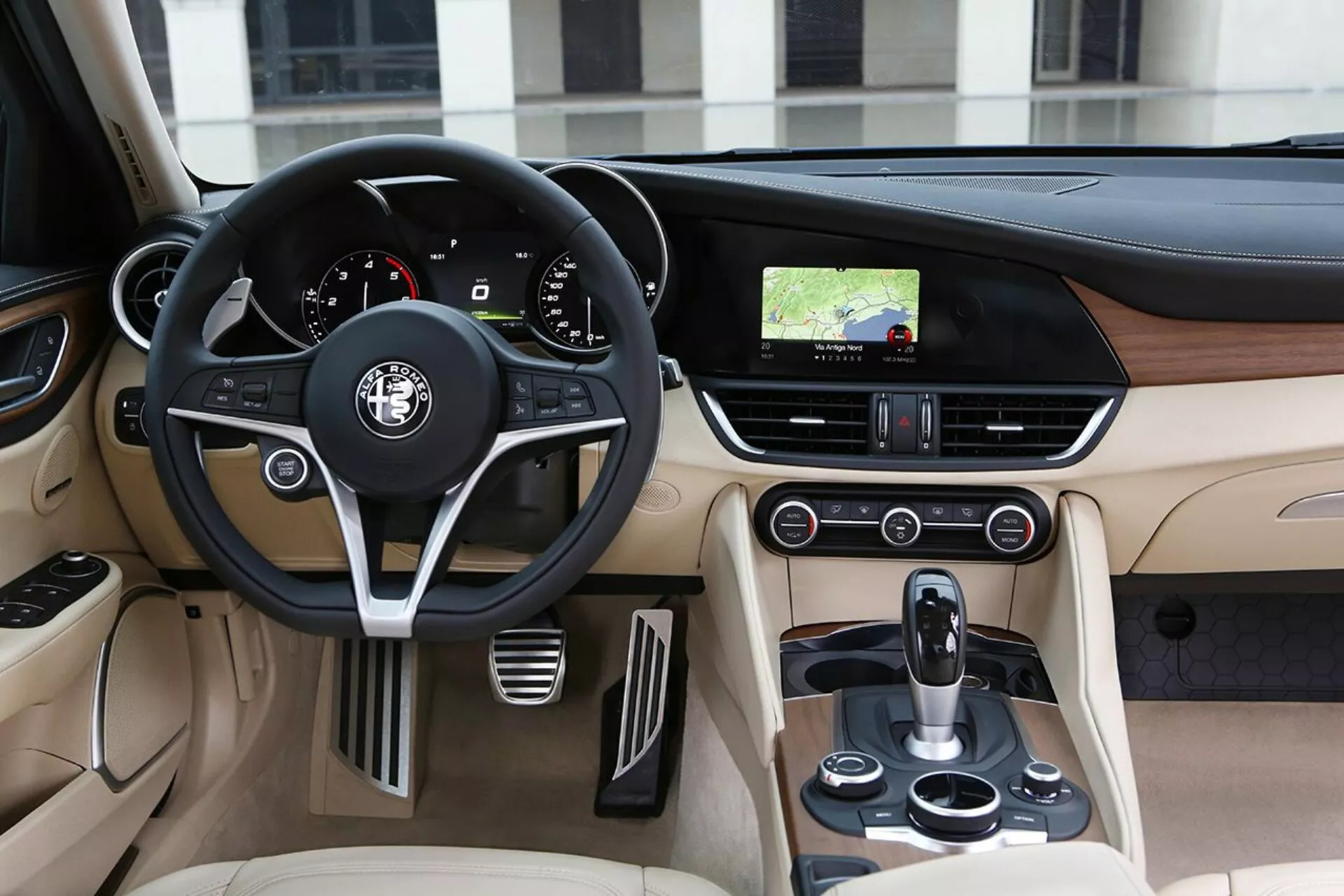 Interior View of 2016 Alfa Romeo Giulia Showcasing Driver's Side With Leather Steering Wheel, Dashboard, and Center Console