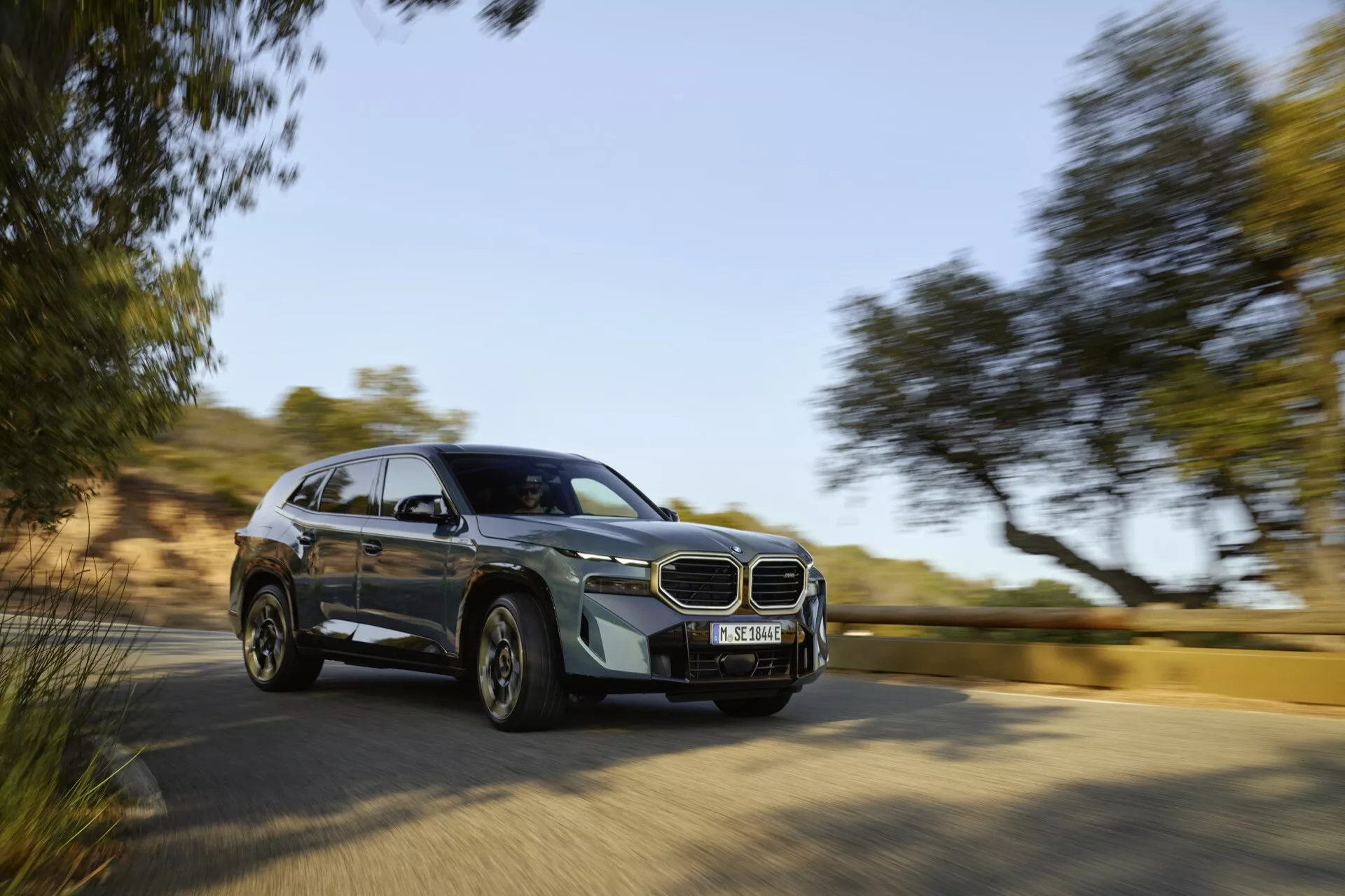 2023 BMW XM (G09) in motion showcasing its modern SUV design from a dynamic front quarter angle, highlighting advanced features like the iconic grille and LED headlights