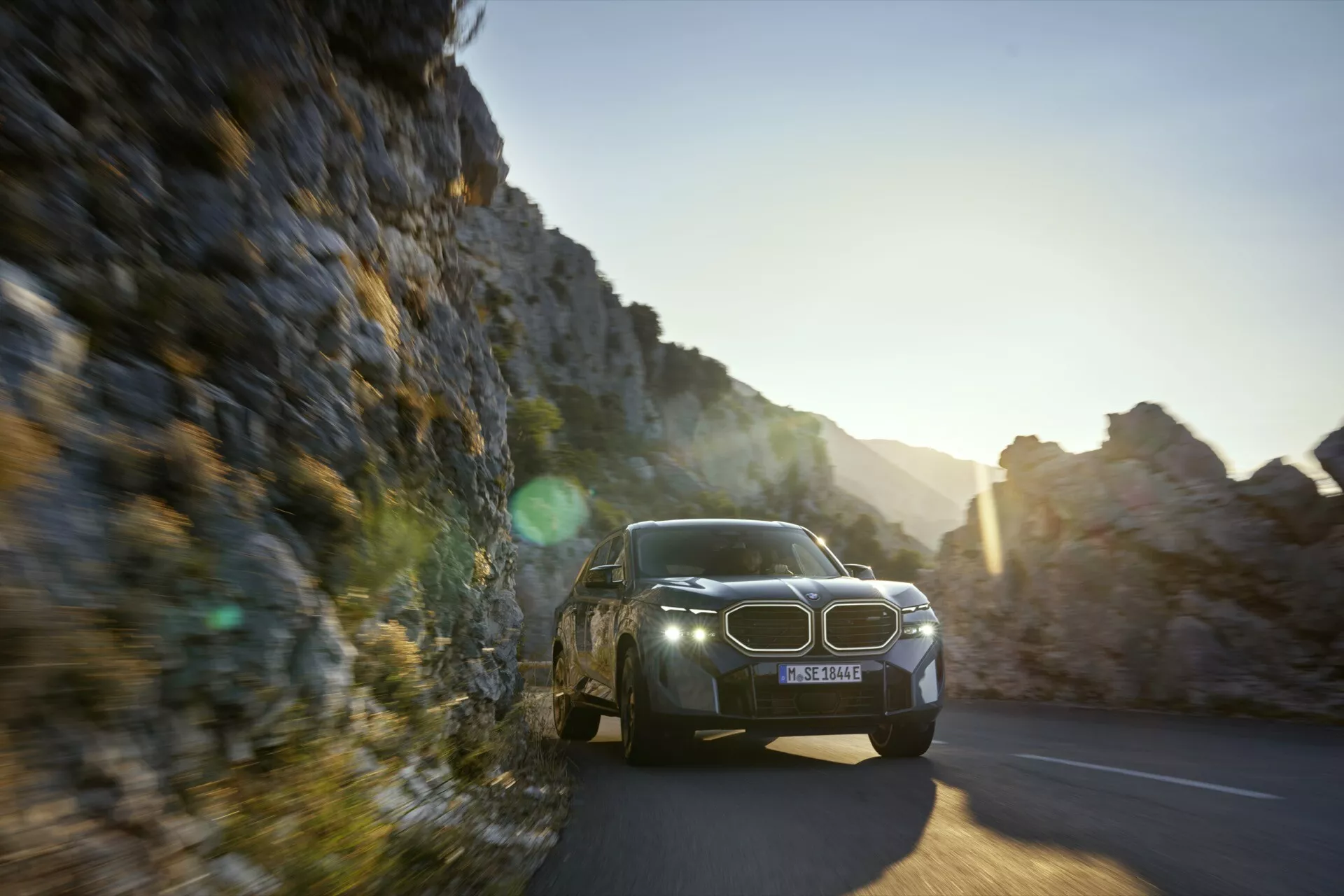 2023 BMW XM (G09) in sleek black color parked outdoors, showcasing its angular design, LED headlights, and large kidney grille