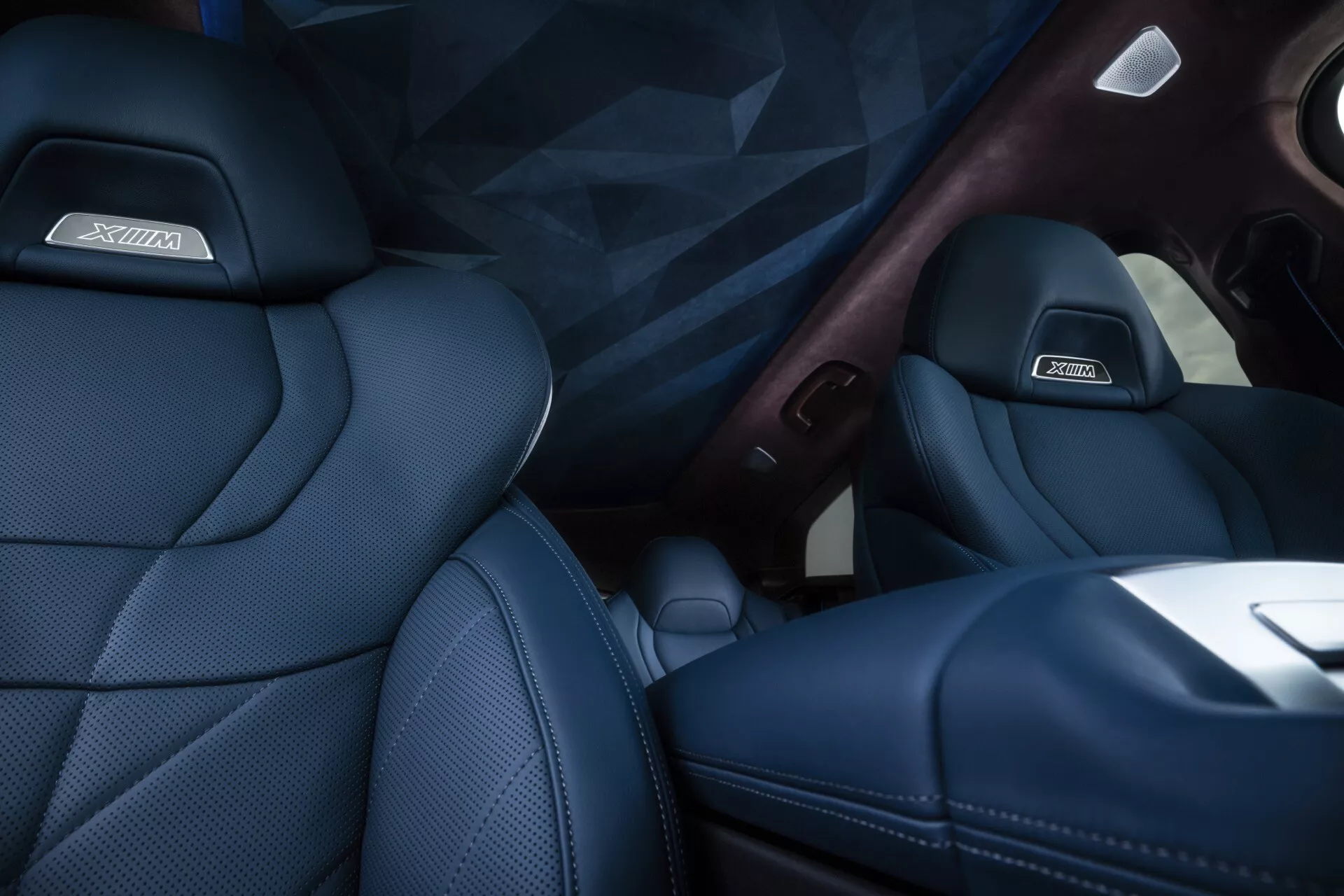 2023 BMW XM (G09) interior view showcasing the luxury passenger seat with dark blue upholstery, wood trim, and technology features