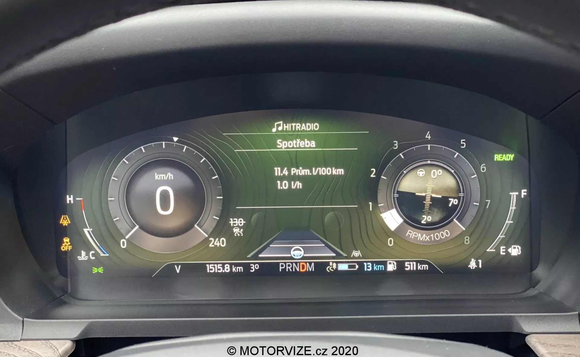 Close-up view of the 2019 Ford Explorer's advanced digital instrument cluster from the driver's perspective, featuring a digital speedometer in kilometers per hour, simulated analog tachometer, multi-information display with media and trip data, odometer reading of 15158 km, cool engine temperature indicator, near full fuel gauge, and several warning lights.