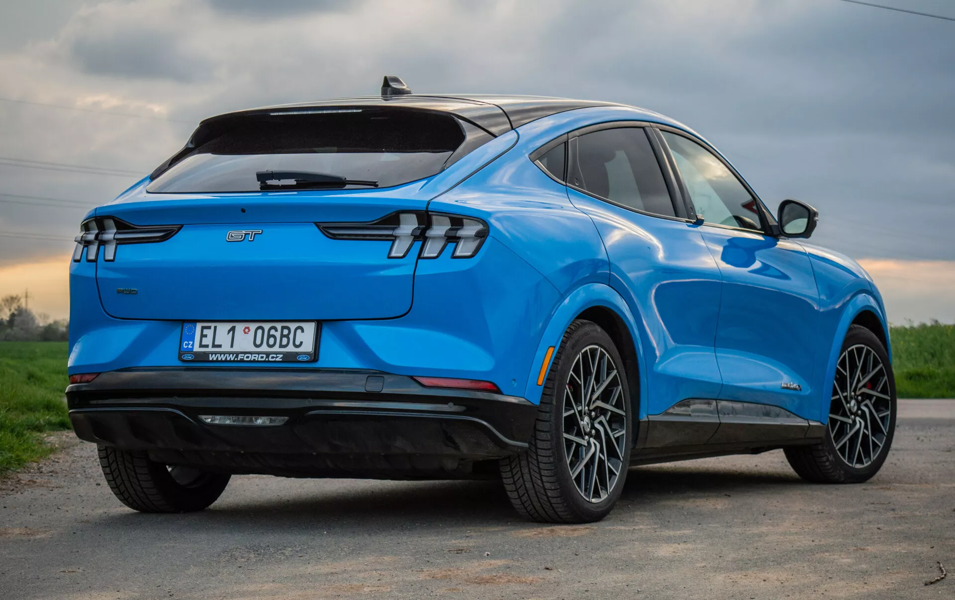 2020 Ford Mustang Mach-E blue electric SUV shown from a three-quarter rear perspective, highlighting its stylish aerodynamic design, modern LED rear lights, multi-spoke alloy wheels, electric vehicle badging, and technological features