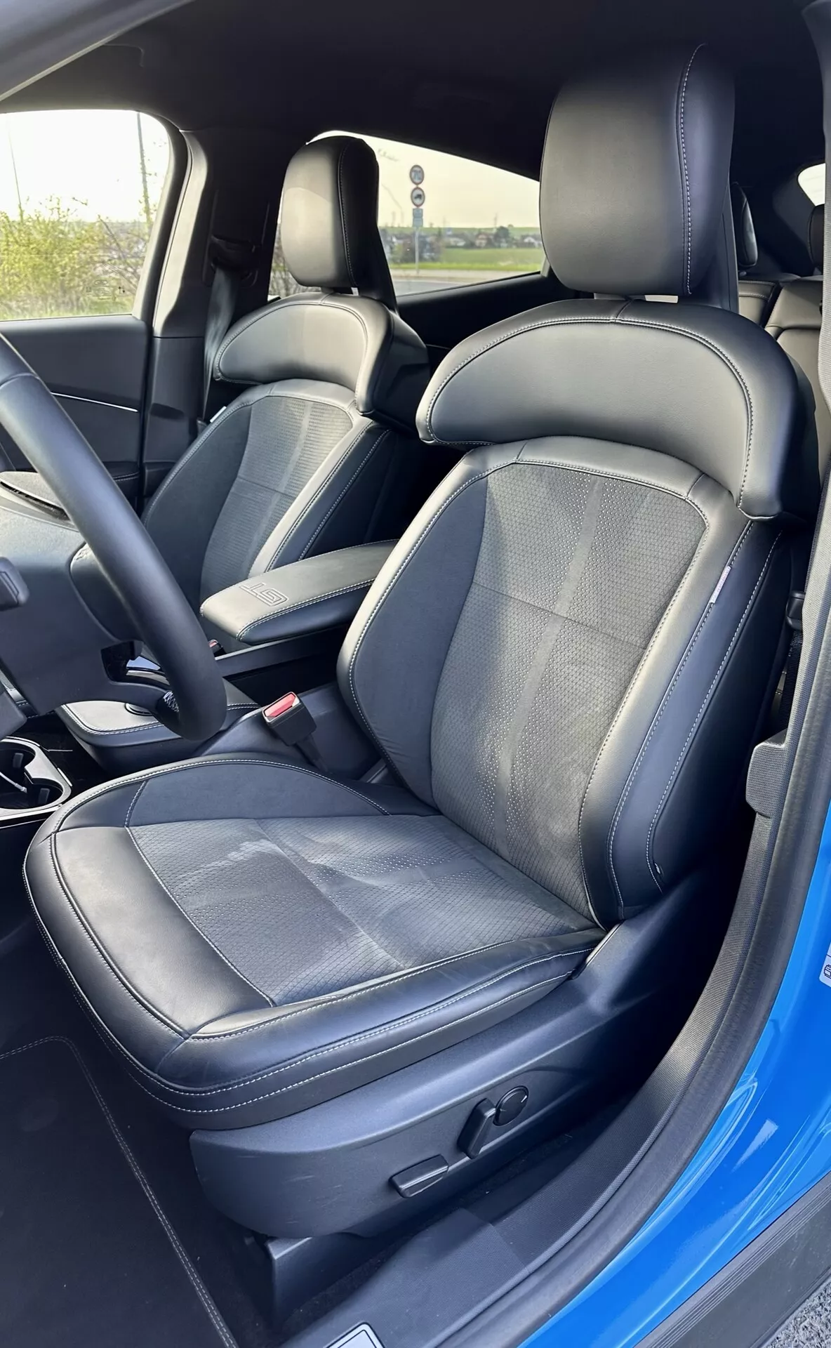 2020 Ford Mustang Mach-E interior showing driver's seat with leather and fabric upholstery, electronic seat adjustment, and safety belt