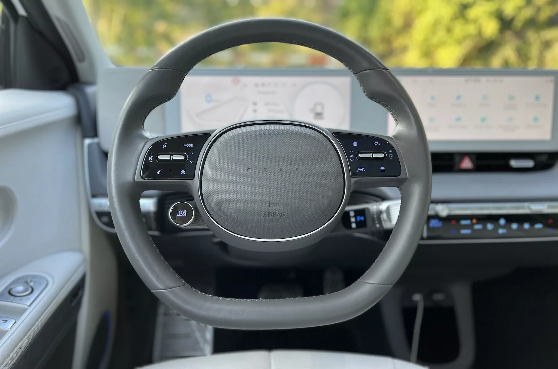 2021 Hyundai Ioniq-5 interior view focusing on the premium design steering wheel and high-resolution digital dashboard from the driver's perspective, showcasing multifunctional touch-sensitive controls and advanced technology features