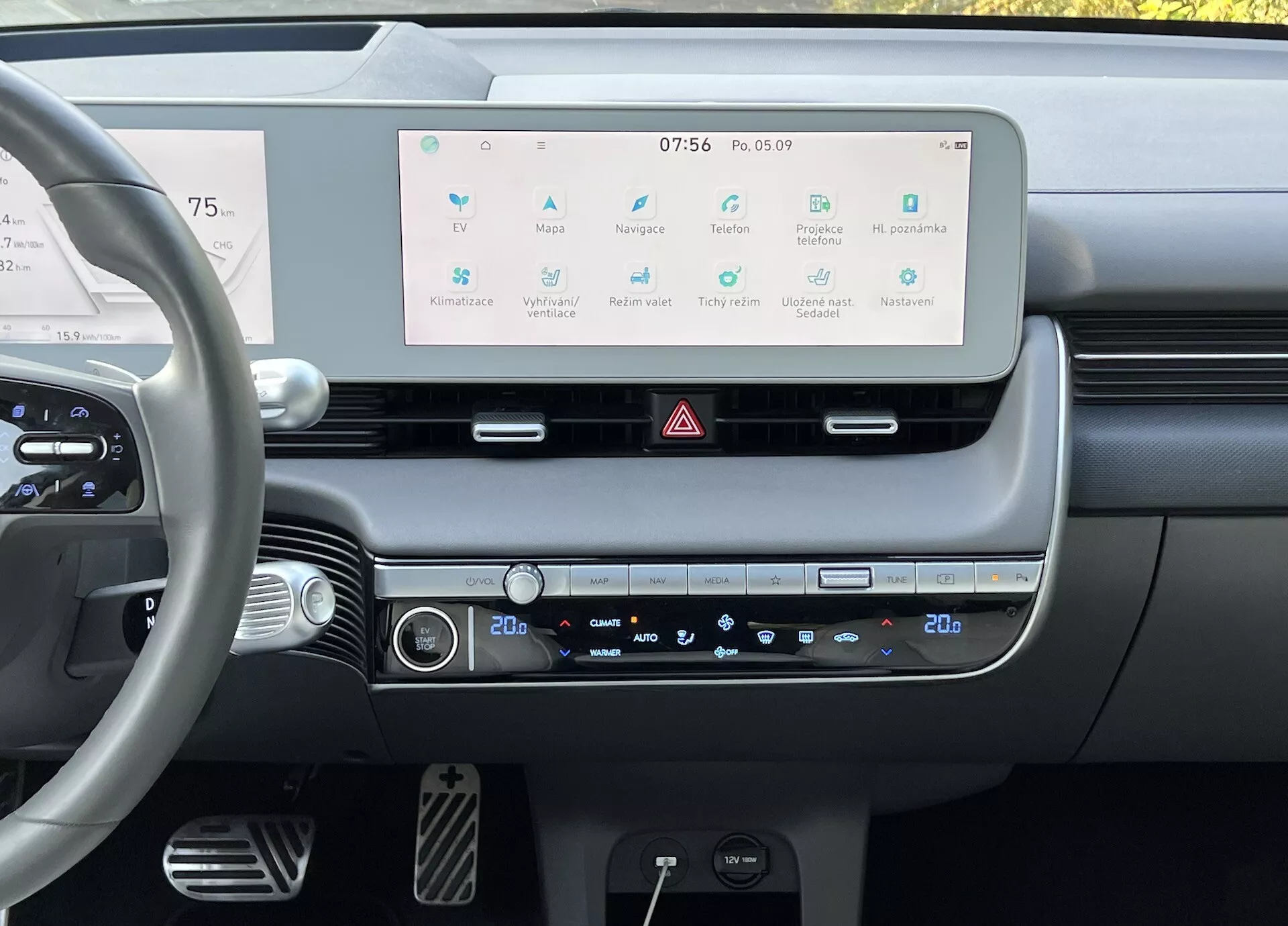 2021 Hyundai Ioniq 5 interior showing a driver's perspective of the dashboard with a large infotainment touchscreen display, dual-zone climate control, and modern steering wheel controls, emphasizing the car's advanced technology and minimalist design.