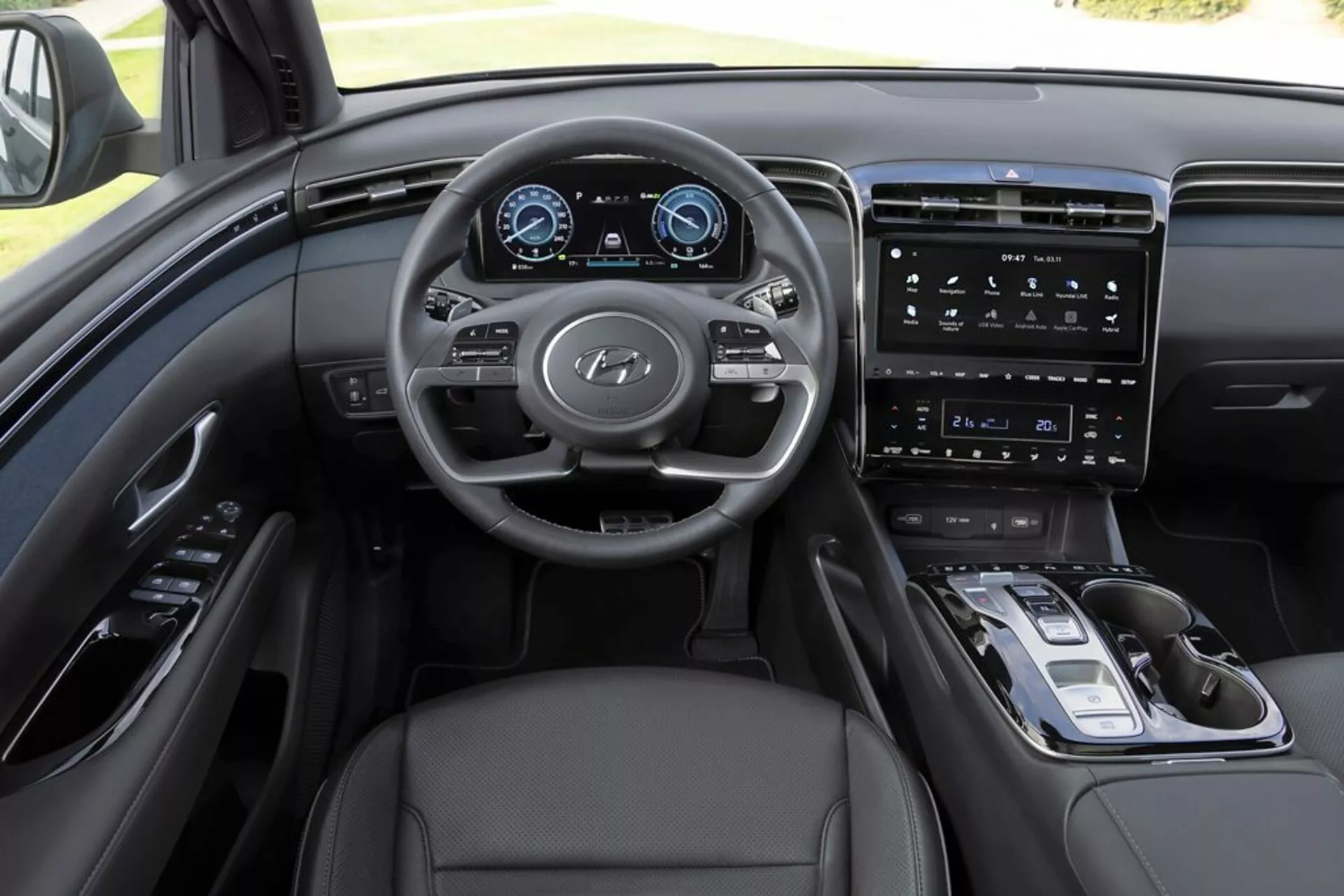 2020 Hyundai Tucson interior view from driver's perspective, highlighting dashboard, multi-function steering wheel with Hyundai logo, digital instrument cluster, vertical touchscreen infotainment system, minimalistic center console controls, electronic gear selector, leather upholstery, and sophisticated monochromatic color scheme