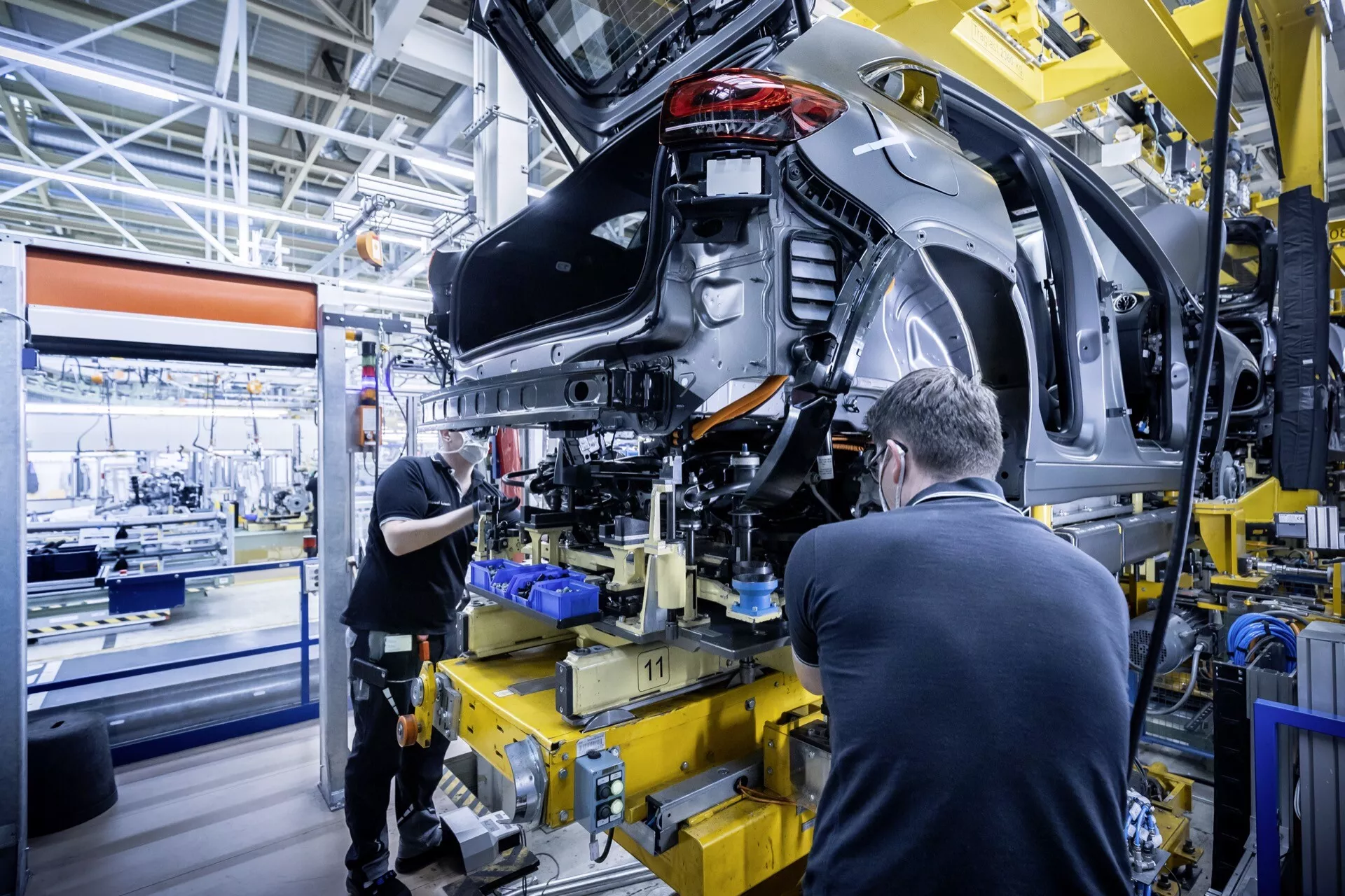 2021 Mercedes-Benz EQA (243) in mid-assembly showing rear left quarter with exposed internals and suspension, in a modern automotive manufacturing facility