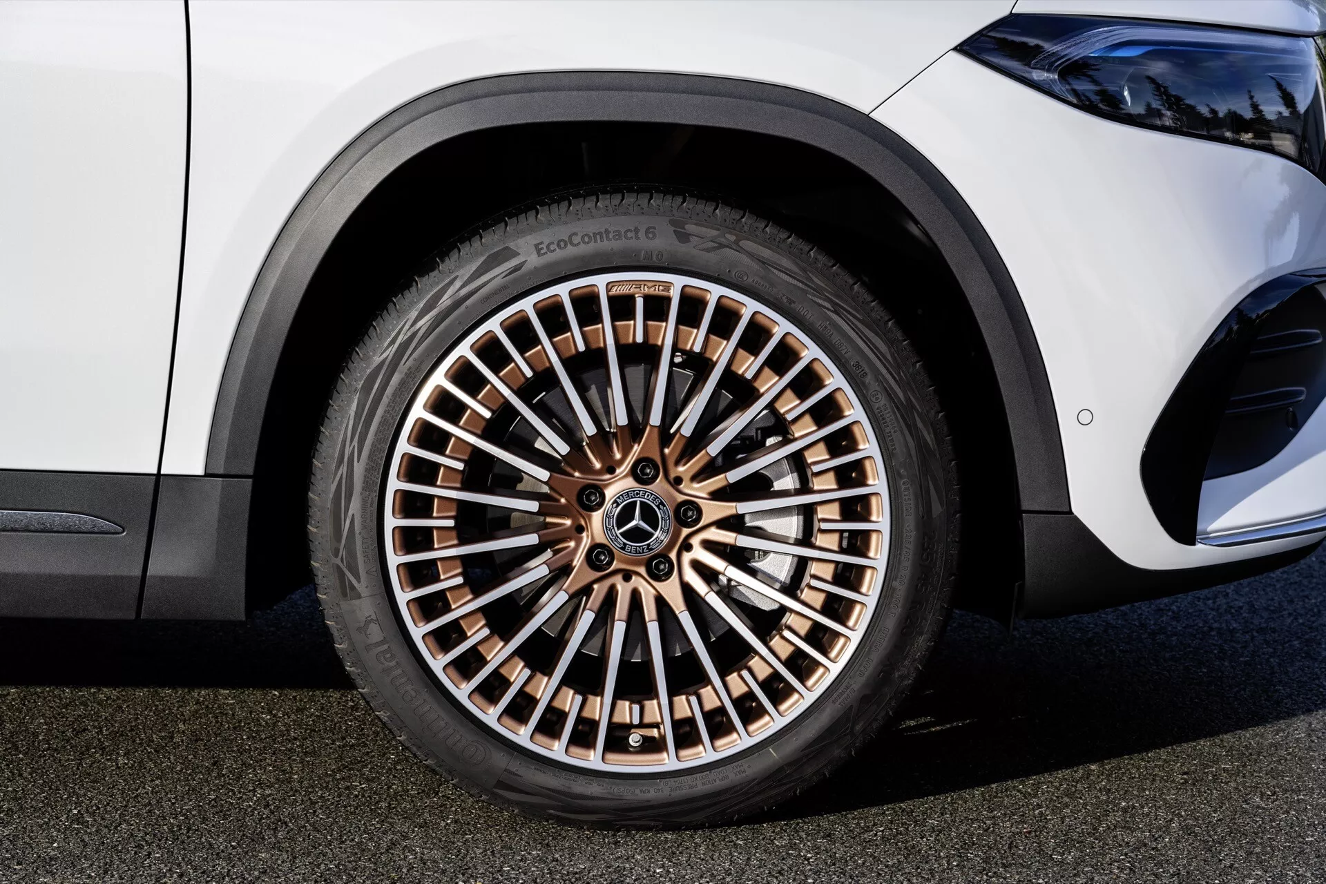 Close-up view of a Mercedes-Benz EQA 2021 wheel showcasing a multi-spoke rim in bronze tone and high-profile EcoContact tire, reflecting luxury and eco-friendly design elements