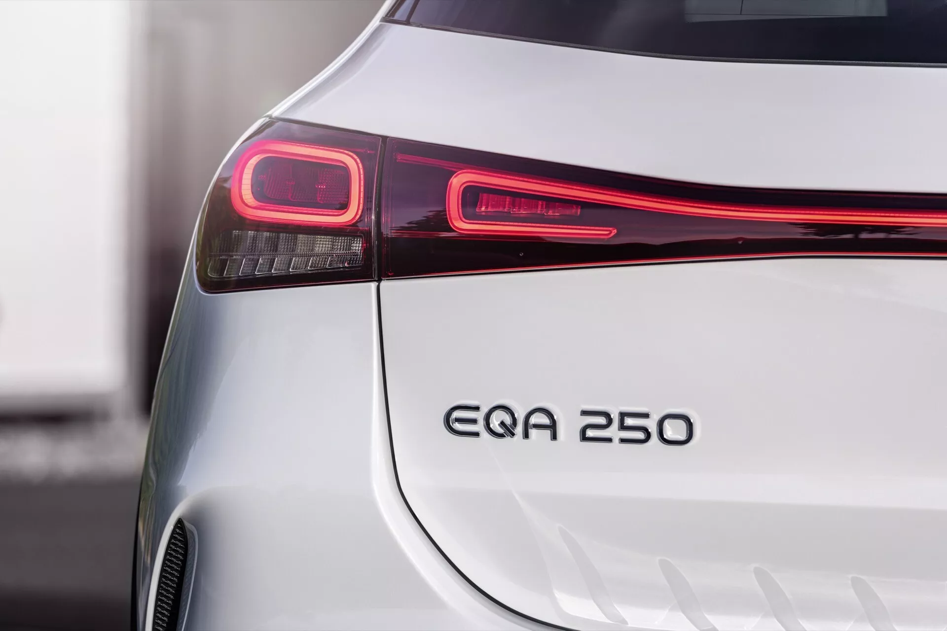 Close-up image showing the sleek rear detailing of a silver Mercedes-Benz EQA 2021, highlighting its modern LED tail light, EQA 250 badge, and bumper design, indicative of its electric vehicle status