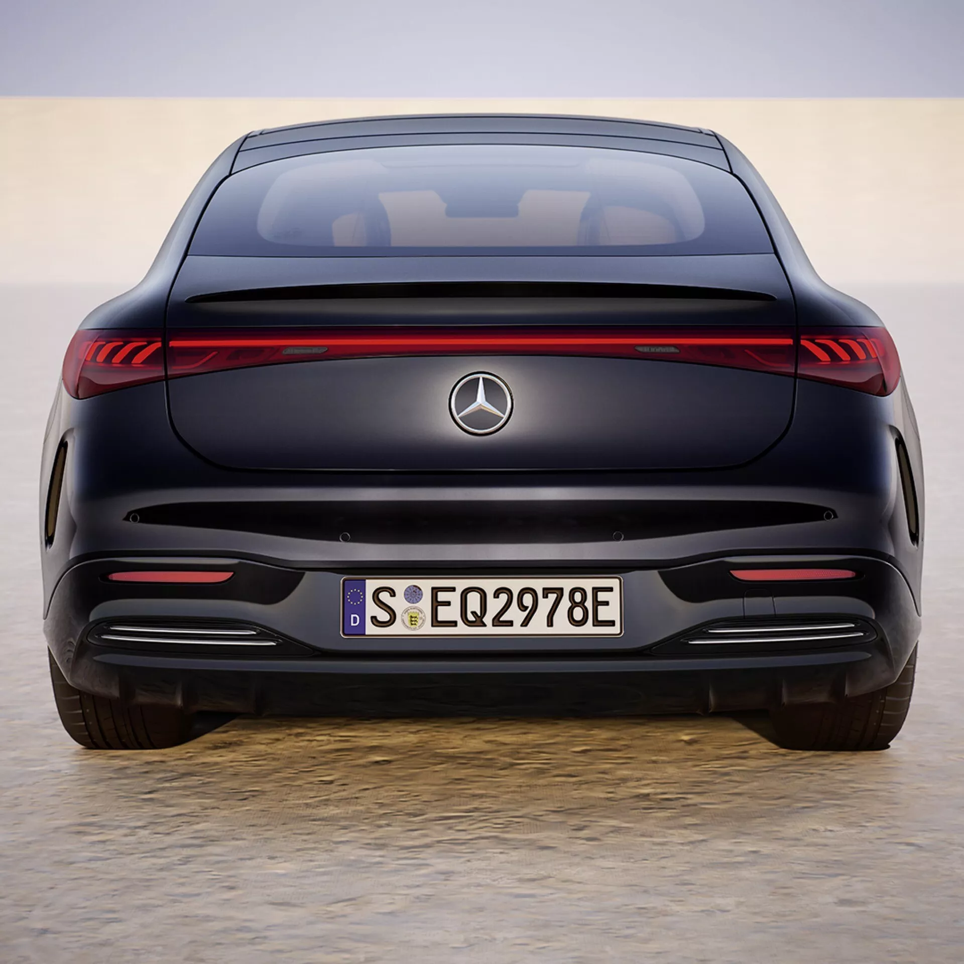 2024 Mercedes-Benz EQS rear view showcasing LED taillights, emblem, EQ and 297E badging on trunk, seamless rear bumper without exhaust, parking sensors, and a coupe-like silhouette indicating luxury electric sedan features
