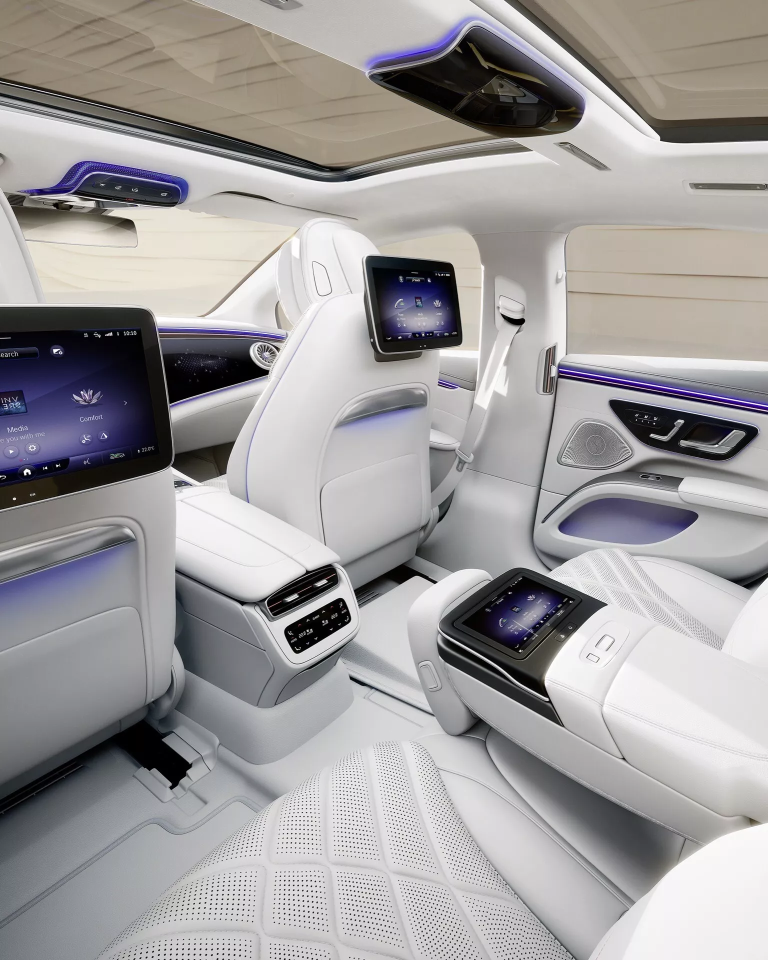 Interior view of the 2024 Mercedes-Benz EQS showing the luxurious rear cabin area with premium leather seats, integrated touchscreen displays on the center console, ambient lighting, and panoramic sunroof