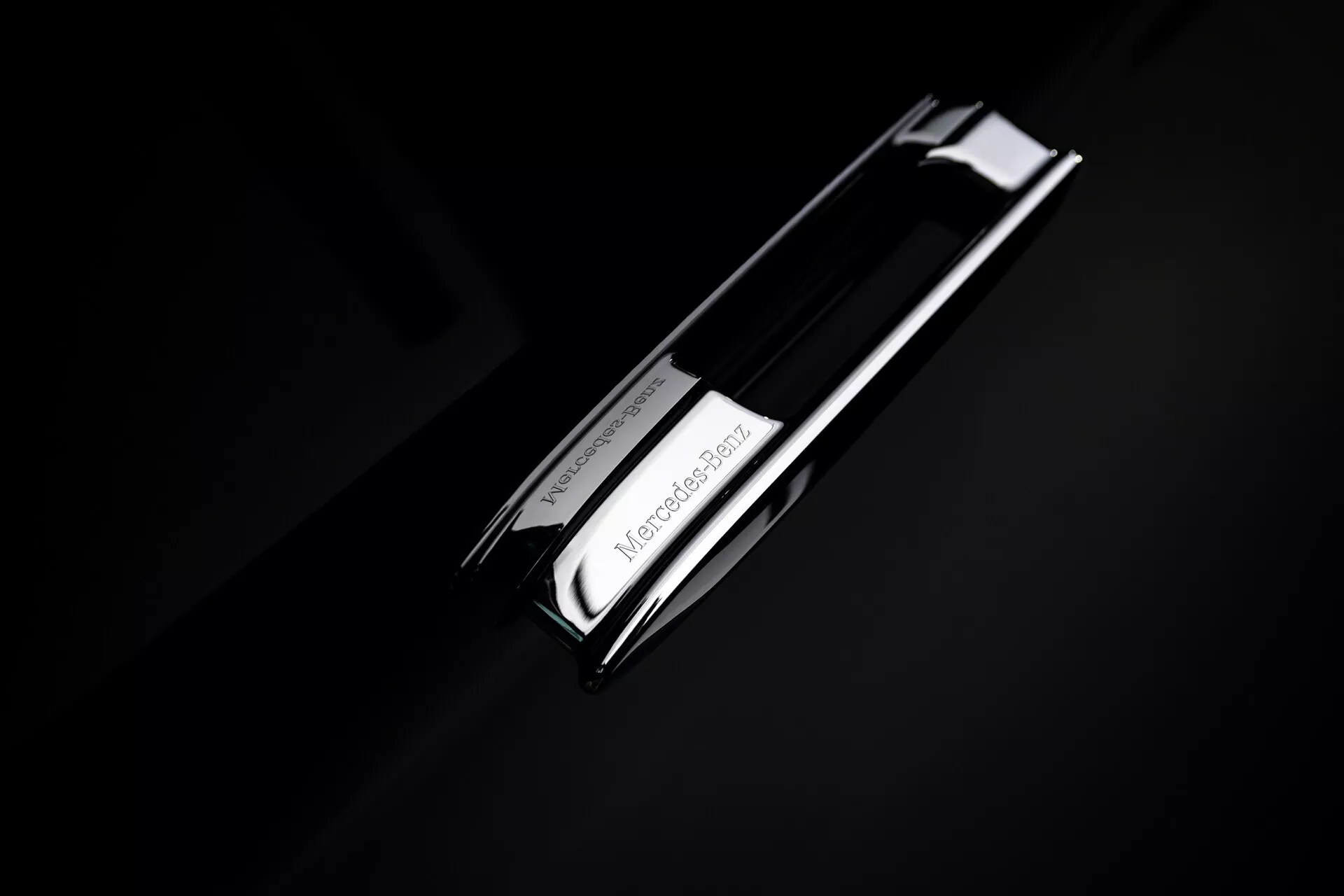 Close-up view of the Mercedes-Benz EQS 2024 (297-facelift) emblem, featuring a chrome three-pointed star logo against a dark background, emphasizing the brand's luxury automotive design.