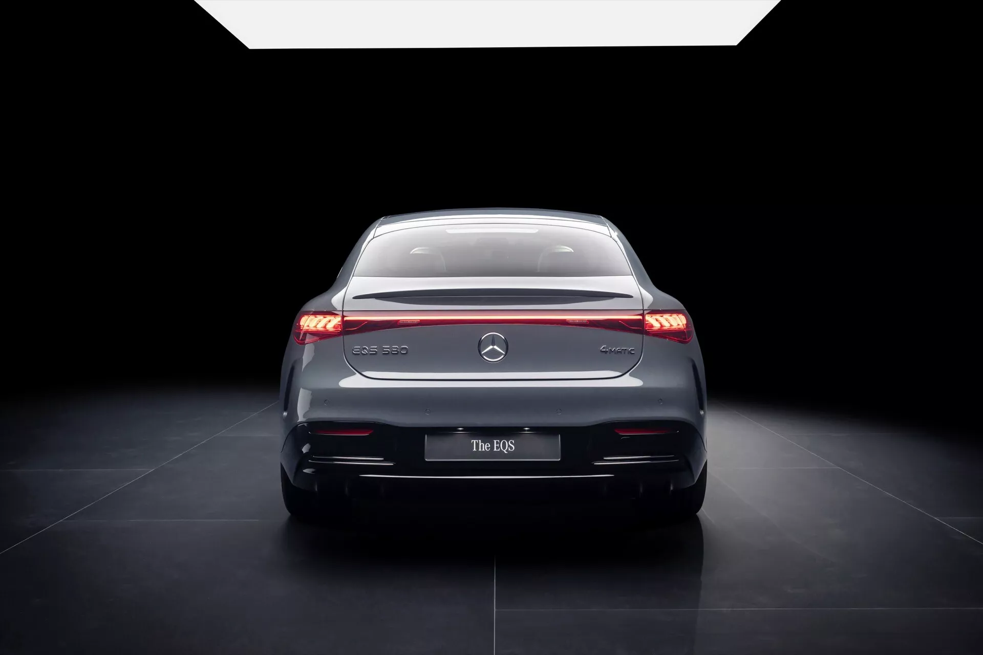 2024 Mercedes-Benz EQS rear view showcasing sleek LED taillights, chrome accents, and a sophisticated design in studio lighting