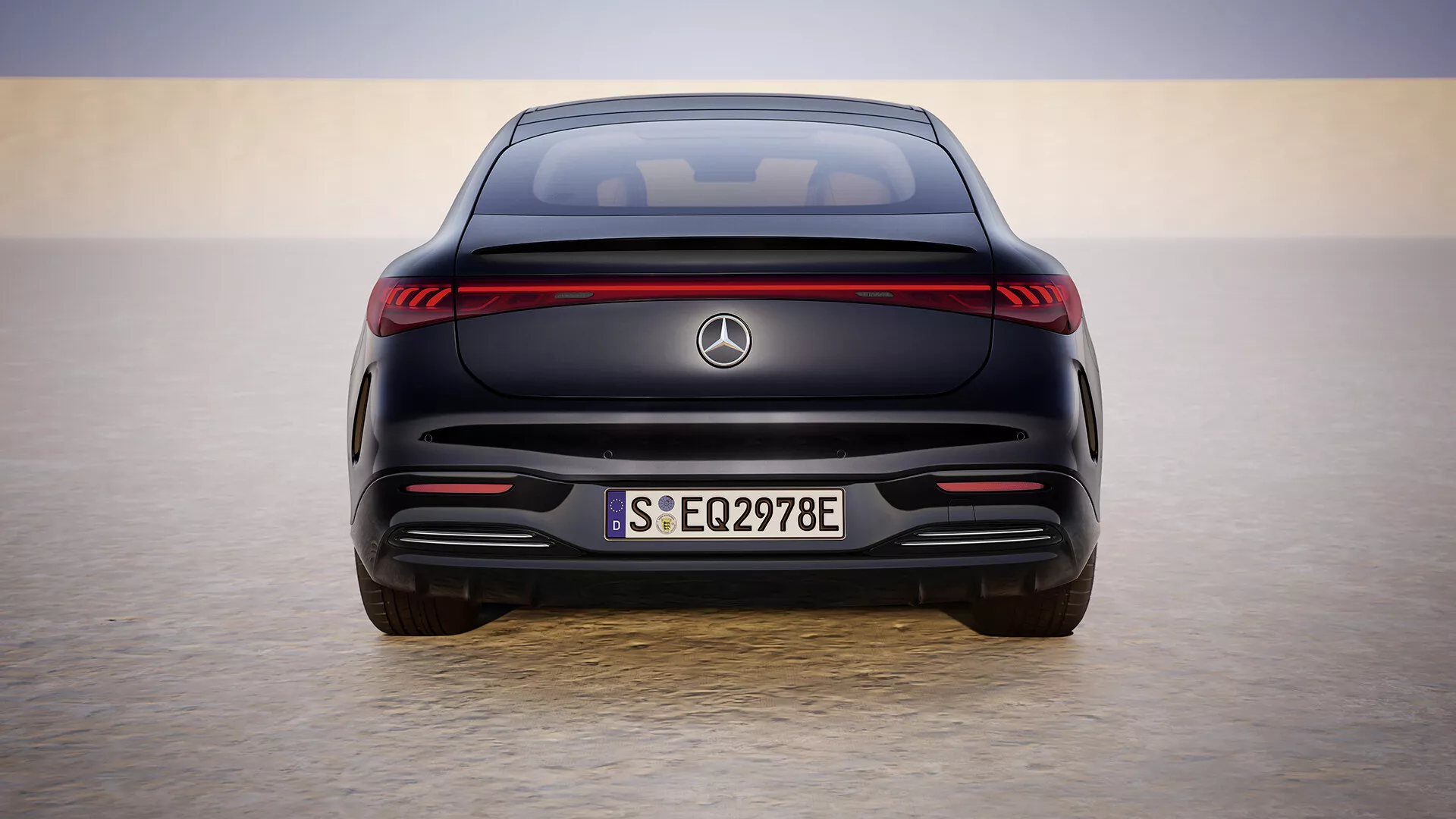 Rear view of 2024 Mercedes-Benz EQS 297 facelift model against a gradient skyline, showcasing its electric vehicle design with LED light strip, European license plate S EQ2978E, no exhaust, and parking assistance sensors.