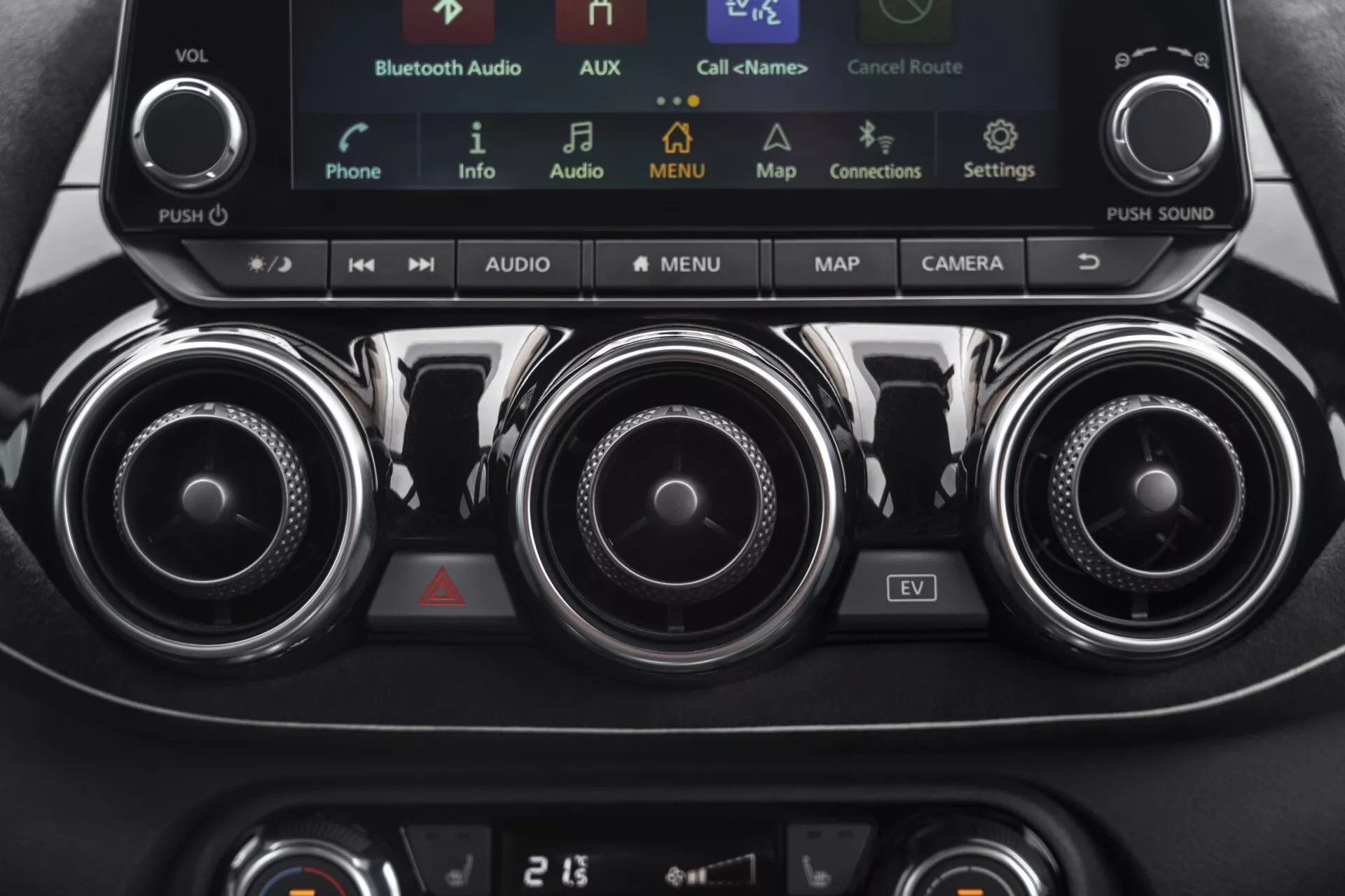 Detailed view of the 2019 Nissan Juke (F16) center console featuring climate controls, infotainment system with touchscreen display including EV mode, metallic air vents, and climate control panel