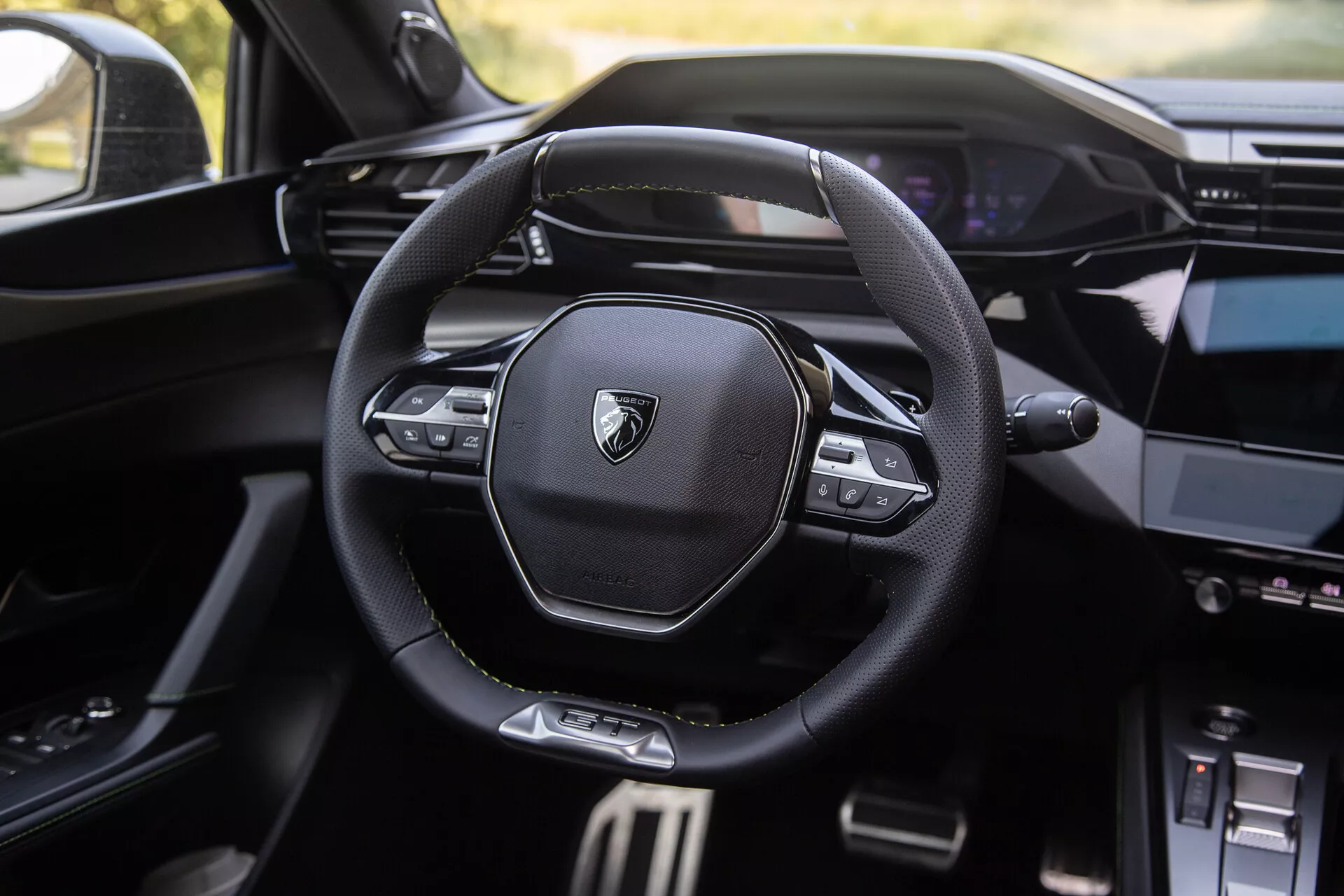 2023 Peugeot 408 interior showcasing modern multi-functional steering wheel with branded logo, digital dashboard in the background, and partially visible center console with infotainment system
