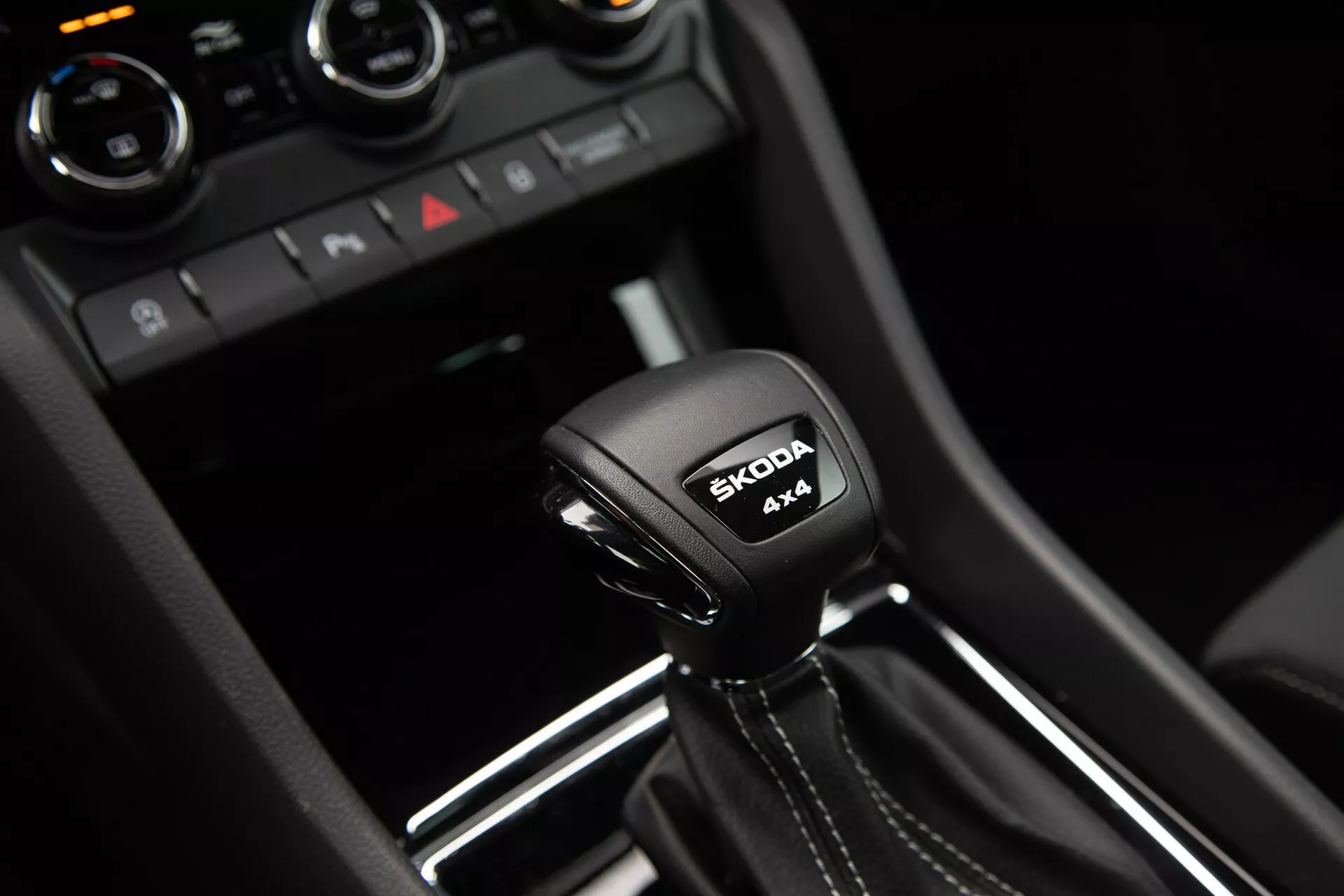 2021 Škoda Karoq automatic transmission gear shift featuring 4x4 system inscription and Škoda logo, encapsulated by modern glossy black and metallic trim interior details.