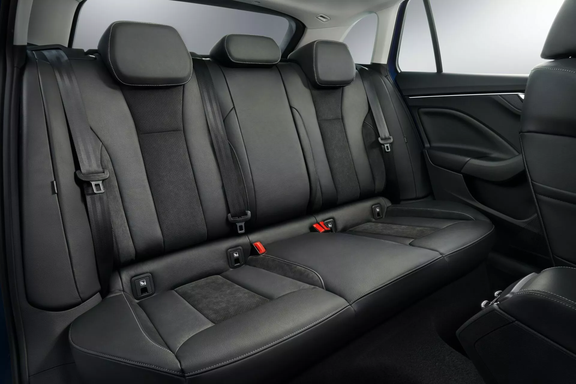 2019 Skoda Scala interior highlighting black leather rear seats with individual headrests, ISOFIX points, three-point seat belts with red release buttons, foldable armrest, and pass-through capability for extra storage, alongside modern vehicle safety and comfort features.