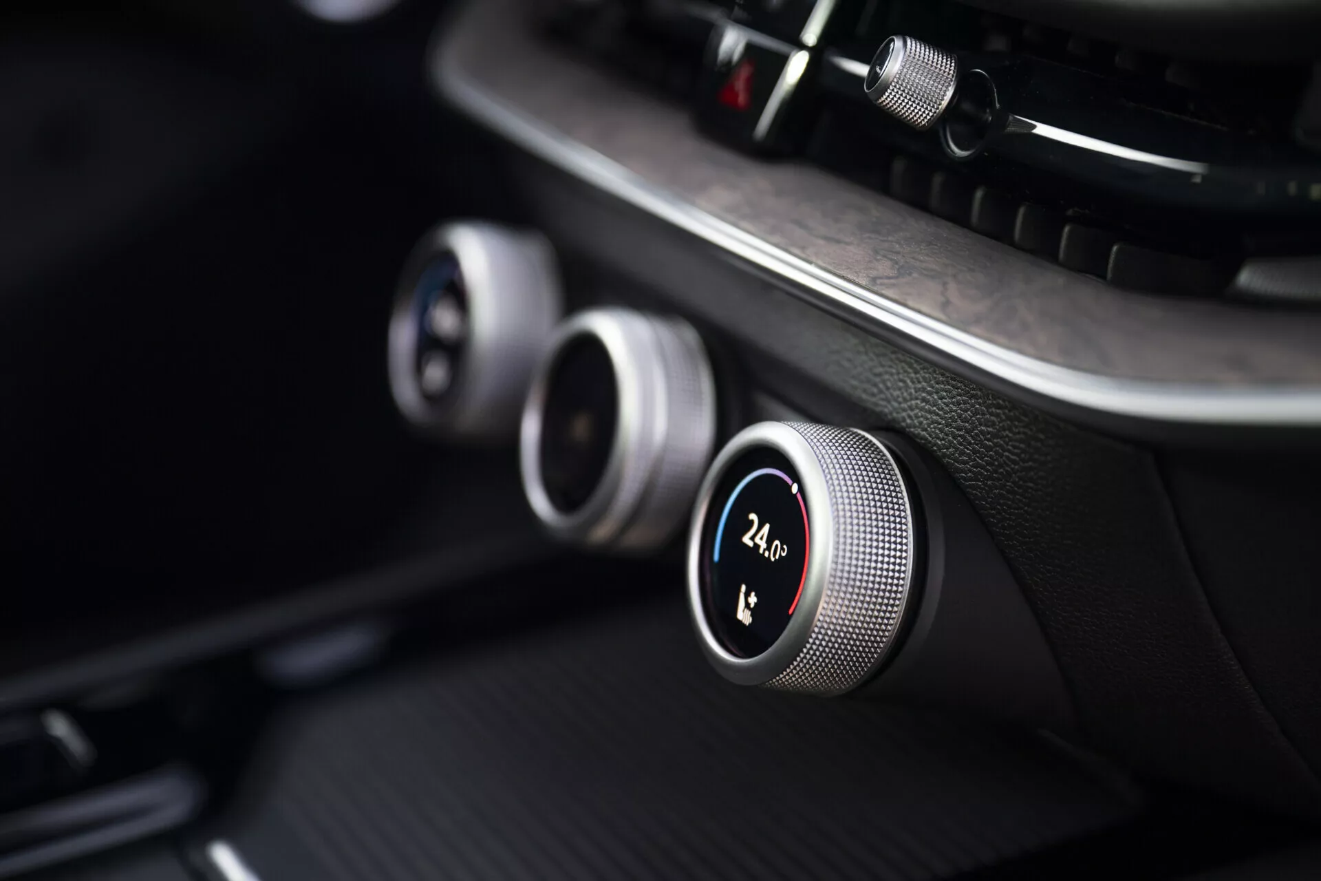 Close-up of Skoda Superb 2024 Combi's dashboard showcasing climate control dials with metallic edges and digital temperature display at 24.5°C, emphasizing modern design and advanced technology