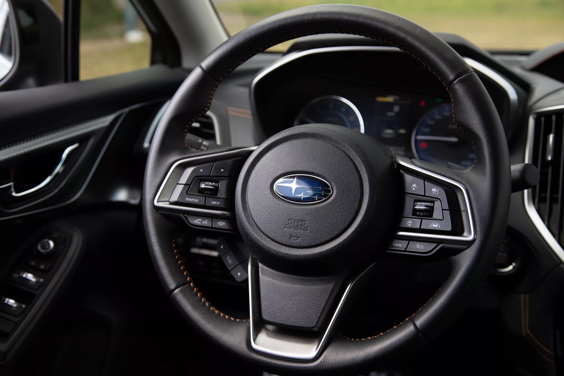 Close-up view of the 2021 Subaru XV's steering wheel highlighting its multifunction buttons, luxurious leather wrapping, and modern dashboard with digital displays