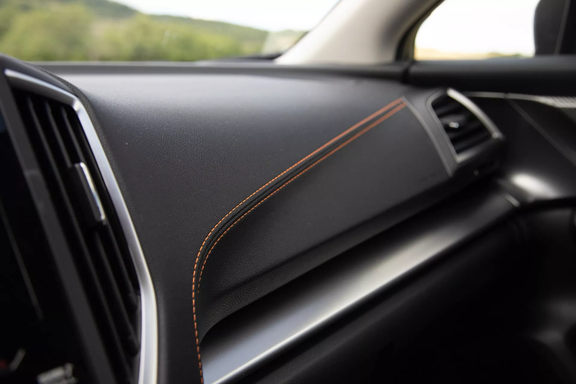 2021 Subaru XV interior detail showcasing premium black material dashboard with contrasting orange stitching, hinting at luxury trim and high build quality