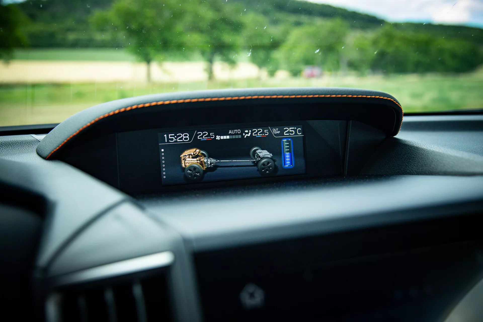 Close-up view of a modern digital dashboard in a 2021 Subaru XV, showing time, temperature, and speed indicators with subtle contrast stitching around the frame, taken from the driver's seat perspective