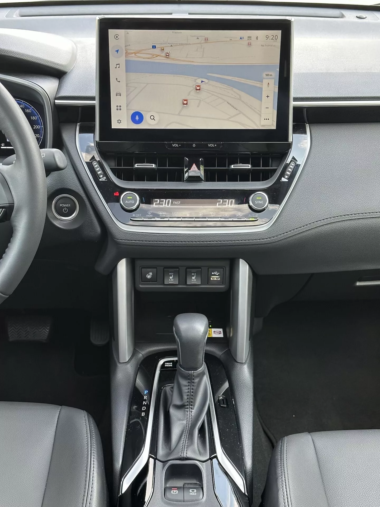 2022 Toyota Corolla Cross interior featuring touchscreen infotainment system with GPS navigation, dual-zone climate control, CD slot, media and phone control buttons, modern automatic transmission shifter, and leather accents in the center console and dashboard design