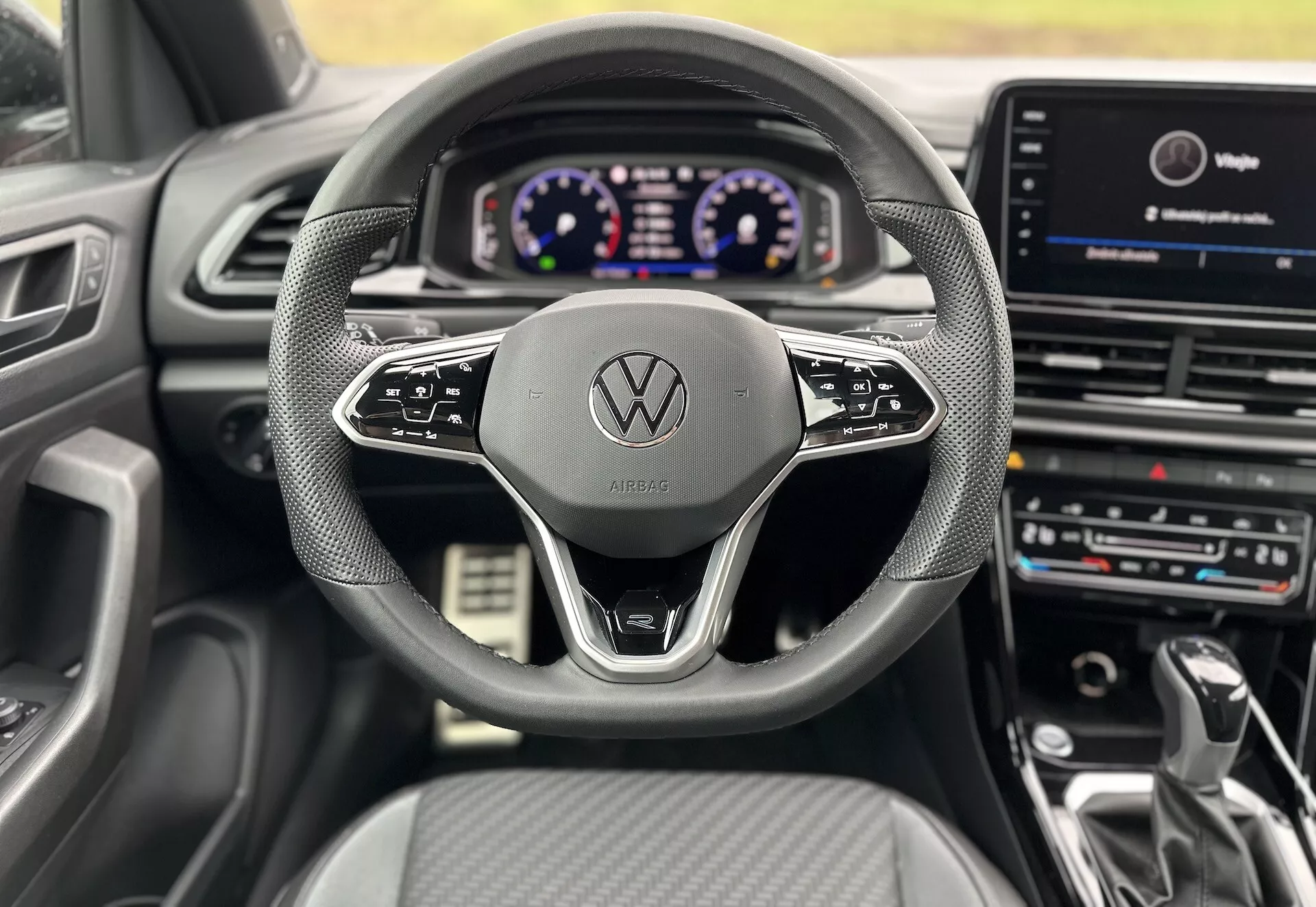 Interior view from the driver's seat of a 2022 Volkswagen T-Roc Cabriolet, showcasing the steering wheel, digital instrument panel, and central infotainment system