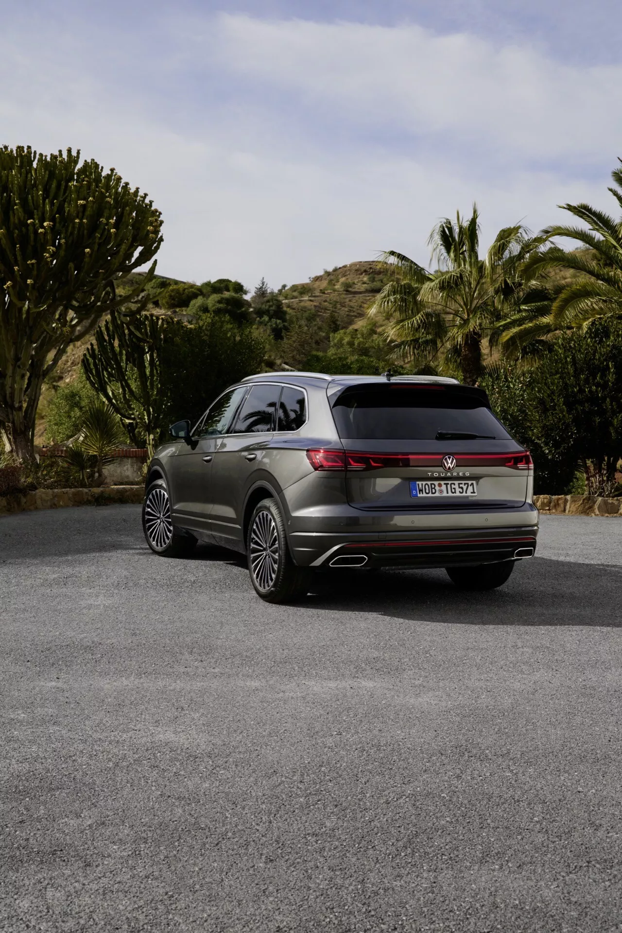 2023 VW Touareg (III-facelift) displayed from a rear three-quarter angle showcasing LED taillights, dual exhausts, and premium alloy wheels on a semi-rural road