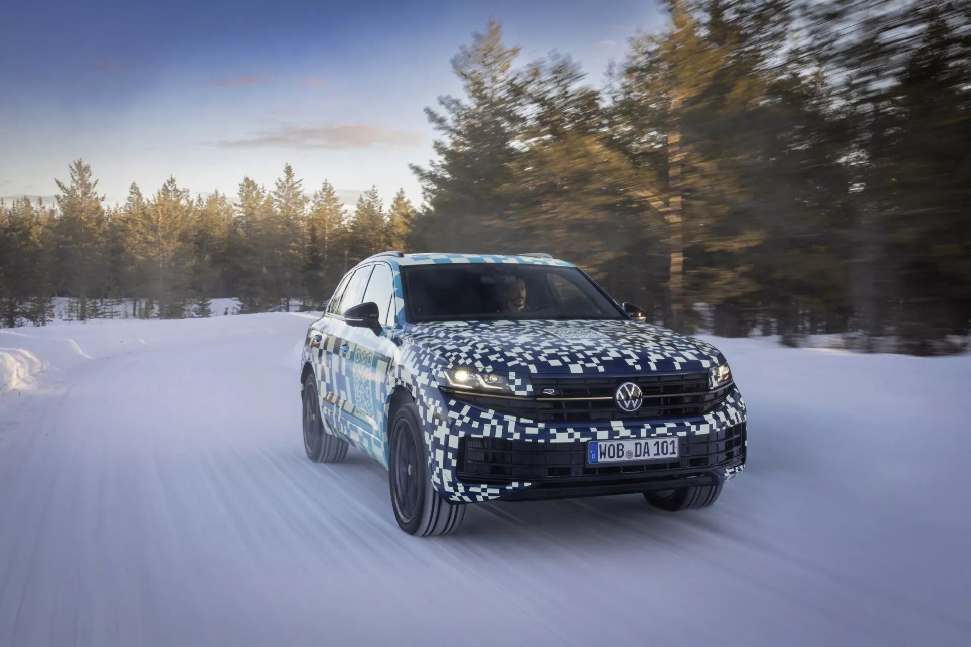 2023 VW Touareg III Facelift model captured in motion on a snowy landscape showcasing dynamic capability and advanced technology features from a front three-quarter perspective